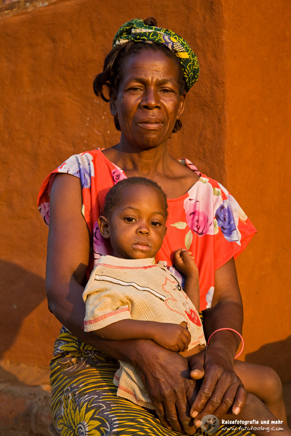 Frau mit Kind vor ihrem Haus