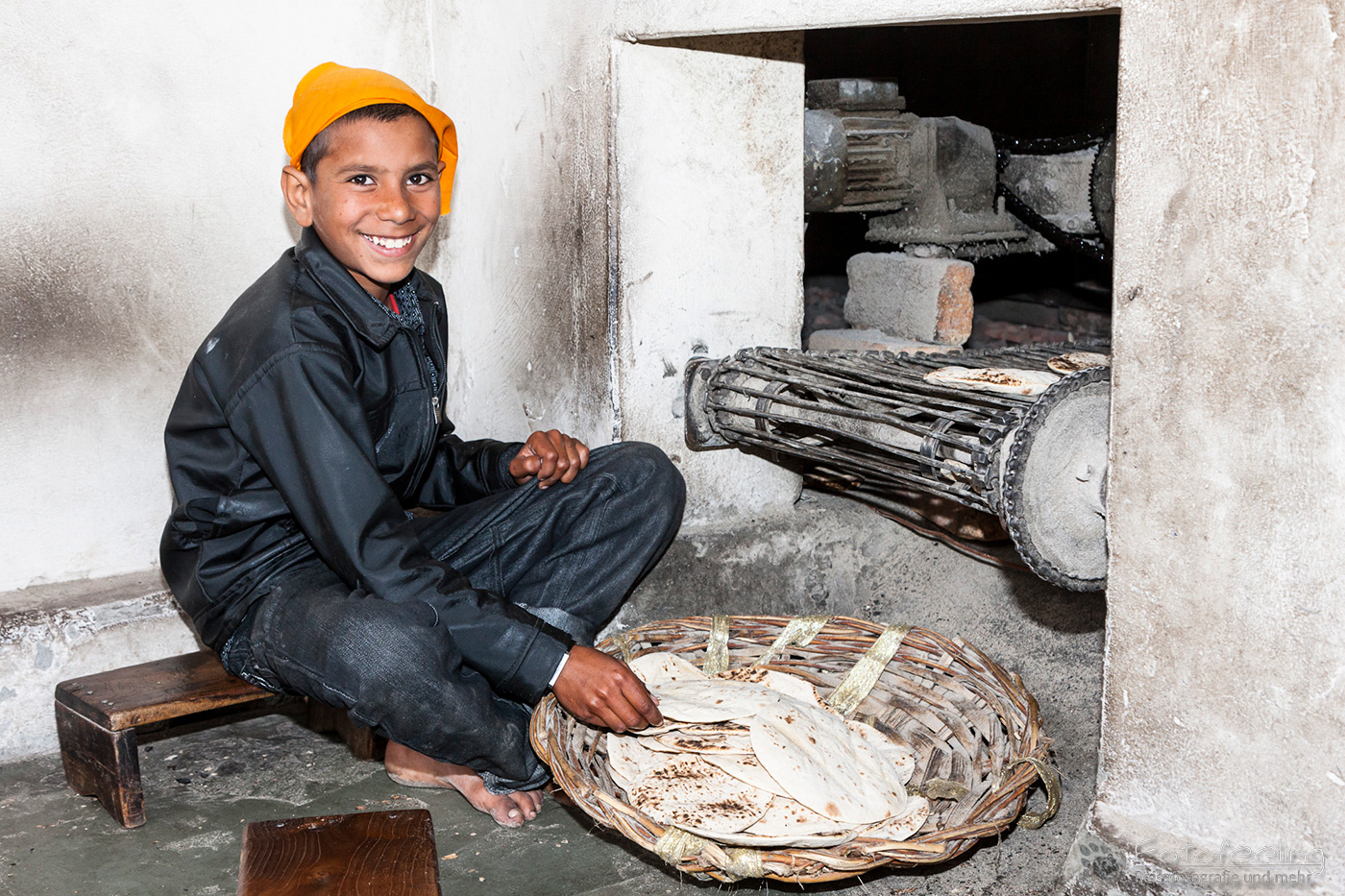 Kleine Junge backt Naan (Indisches Brot)