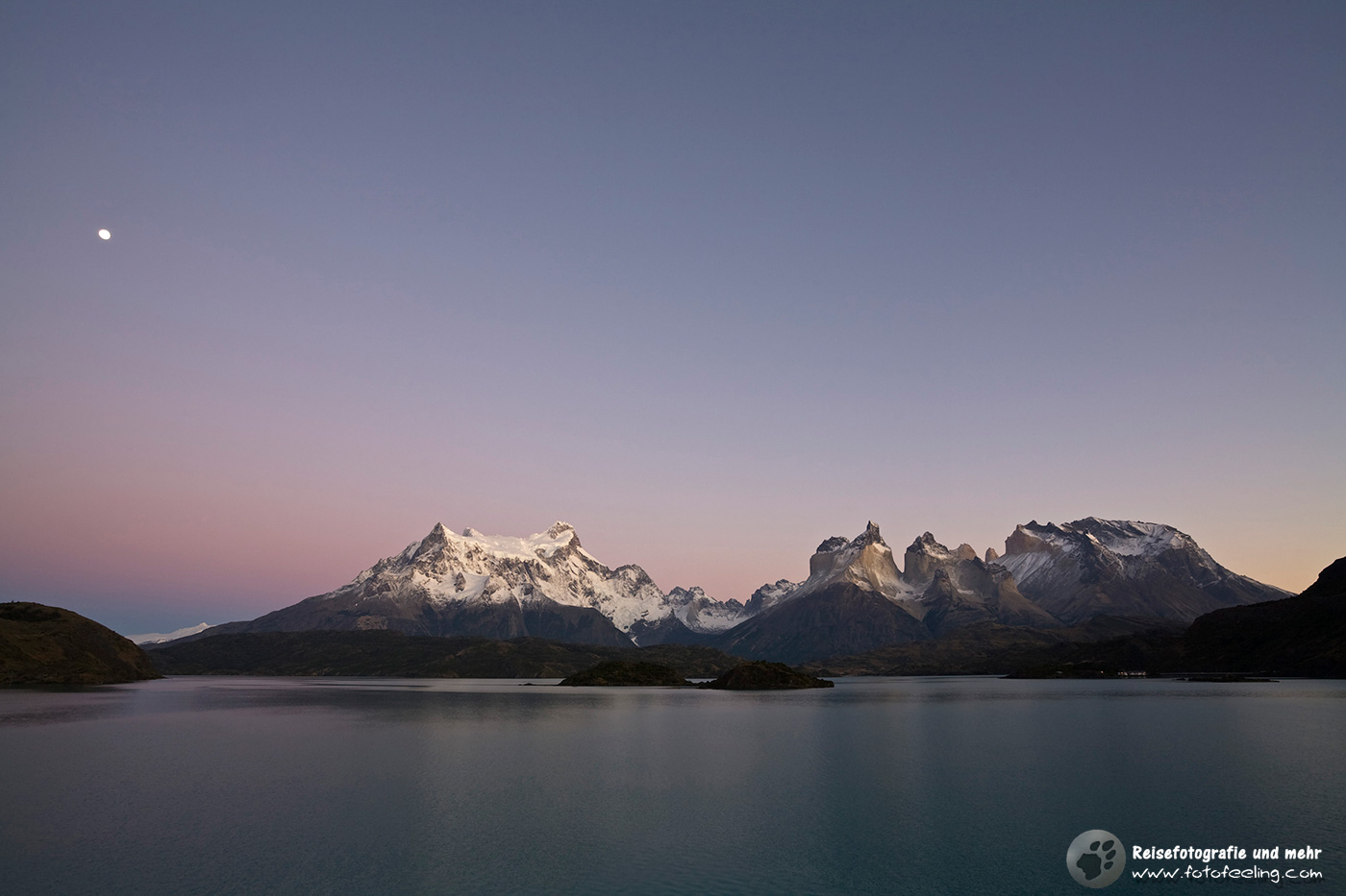 Der Mond bescheint das Torres del Paine Bergmassiv am See Lago Pehoe kurzvor Sonnenaufgang