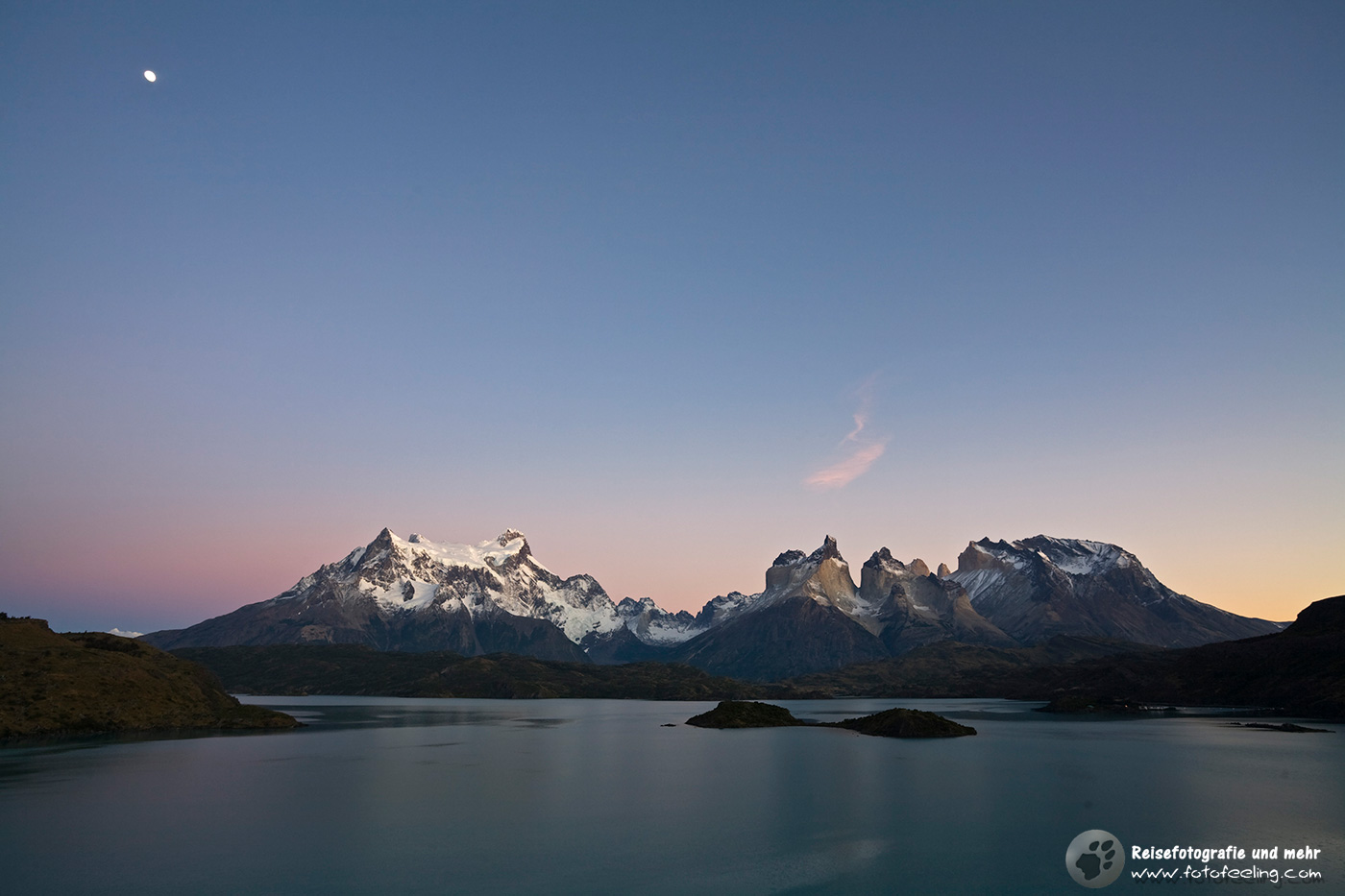 Mond bescheint das Torres del Paine Bergmassiv am See Lago Pehoe kurz vor Sonnenaufgang