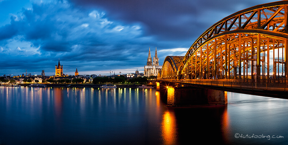 Groß St. Martin (romanische Kirche), Kölner Dom und die Hohenzollernbrücke über dem Rhein zur blauen Stunde